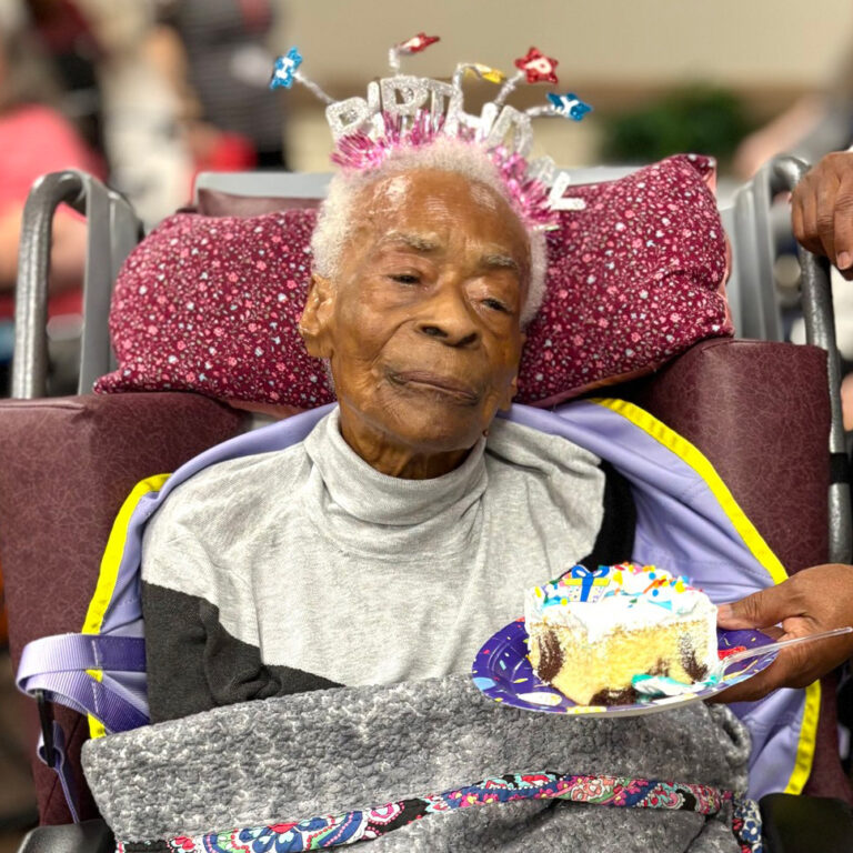 Centenarian Lellar Stewart with Birthday Crown and a slice of birthday cake